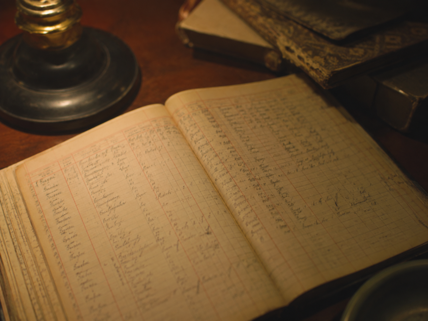 Old paper engineering logbook under warm lamplight